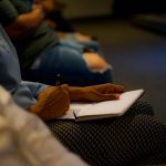 person holding pen and white paper on person lap