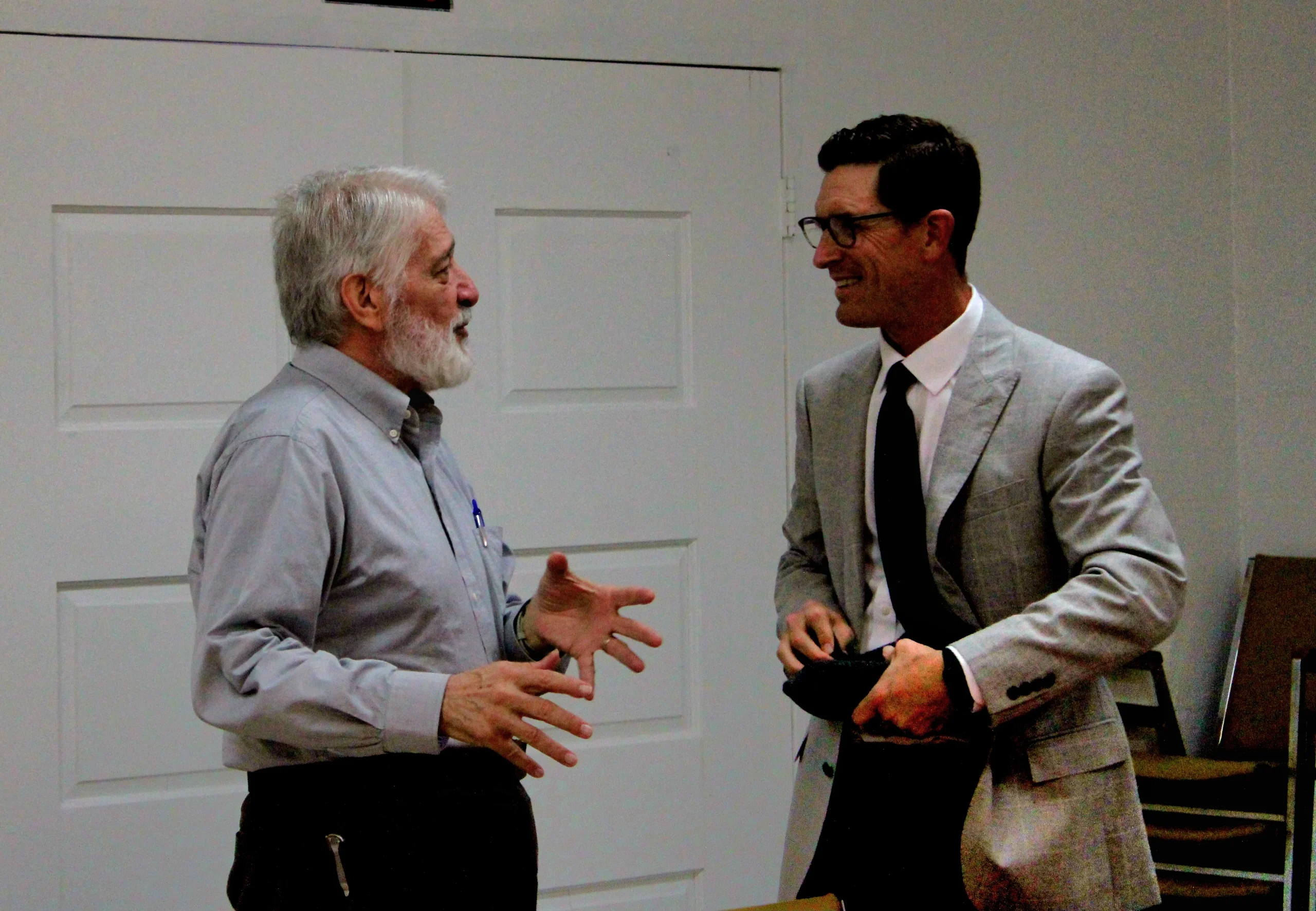 two man and woman standing on doorway